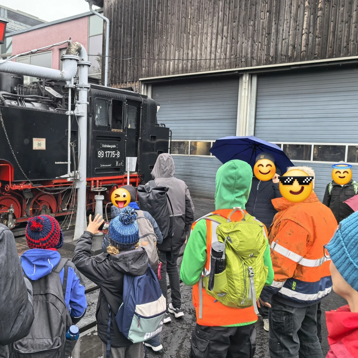 Parkeisenbahnerinnen und Parkeisenbahner besuchen die Fichtelbergbahn, im Hintergrund eine Dampflokomotive