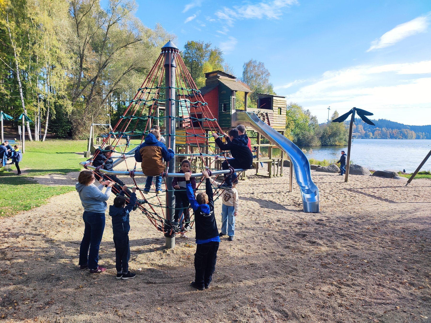 Parkeisenbahnerinnen und Parkeisenbahner fahren Karussel auf dem Spielplatz