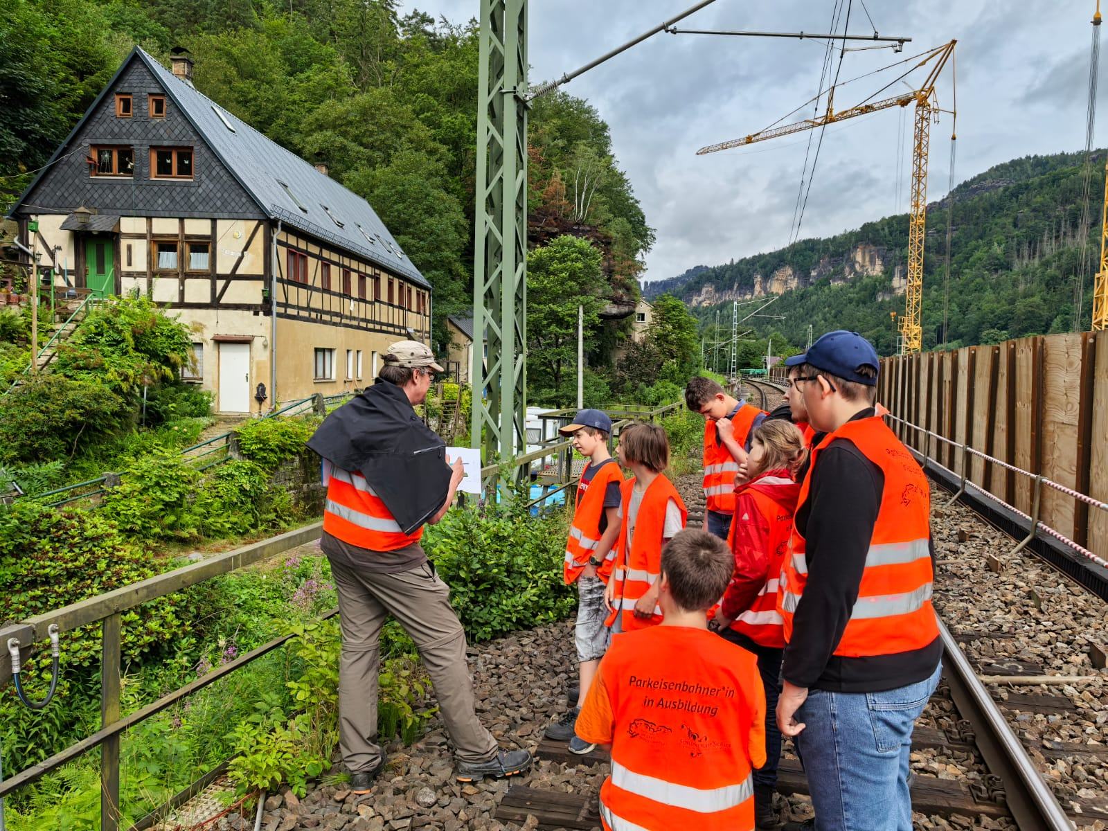 Gruppe Personen mit Warnweste im Gleis
